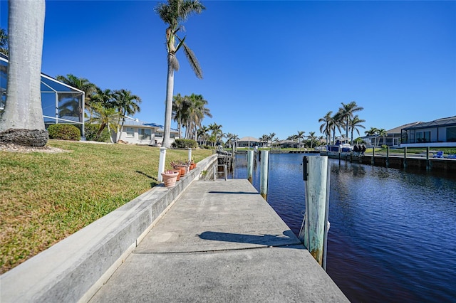 dock area featuring a water view and a lawn