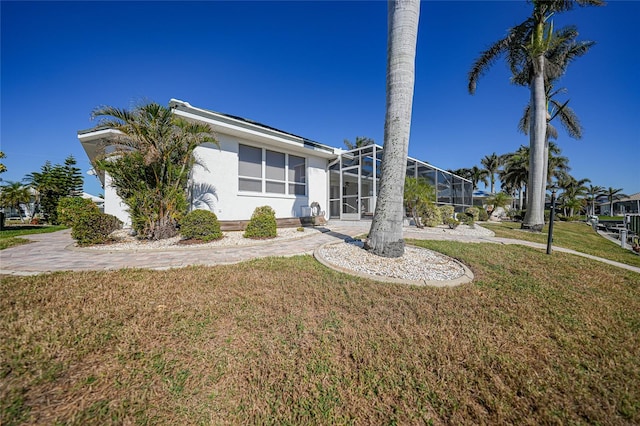 view of front of home with a lanai and a front lawn