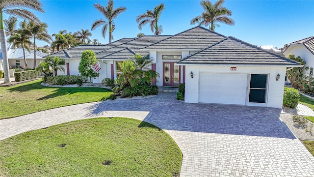 view of front of house with a garage, french doors, and a front lawn