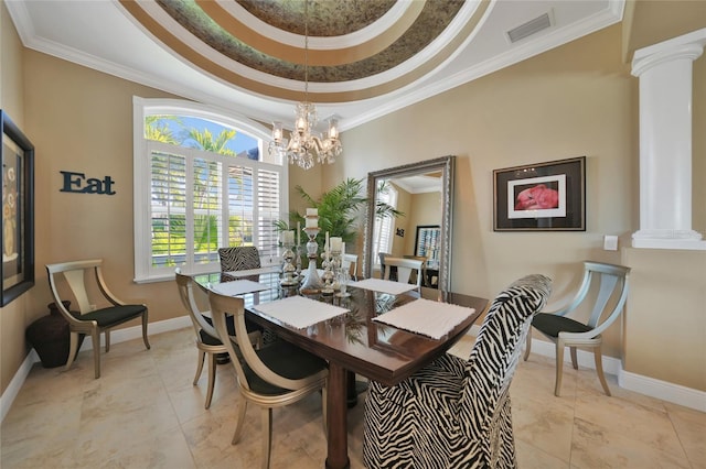 tiled dining room featuring a tray ceiling, ornate columns, crown molding, and an inviting chandelier