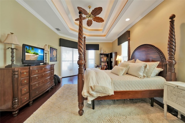 bedroom featuring dark hardwood / wood-style flooring, a tray ceiling, ceiling fan, and crown molding