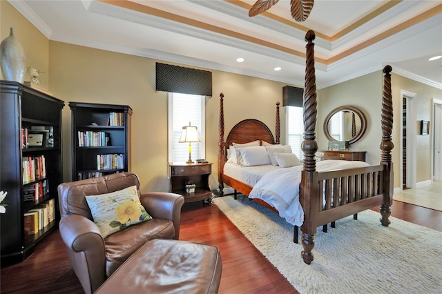 bedroom with a tray ceiling, dark hardwood / wood-style floors, and ornamental molding