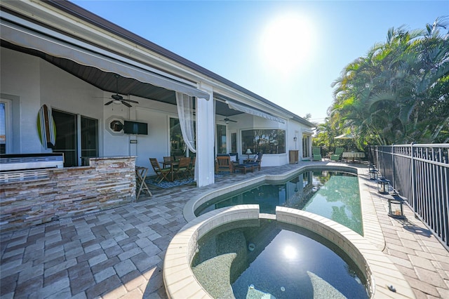 view of swimming pool with an in ground hot tub, a patio, and ceiling fan