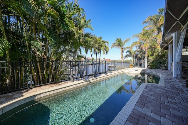 view of swimming pool with a water view and a patio area