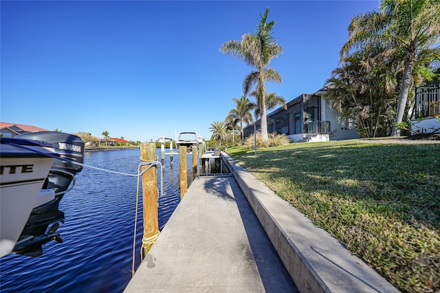 dock area featuring a lawn and a water view