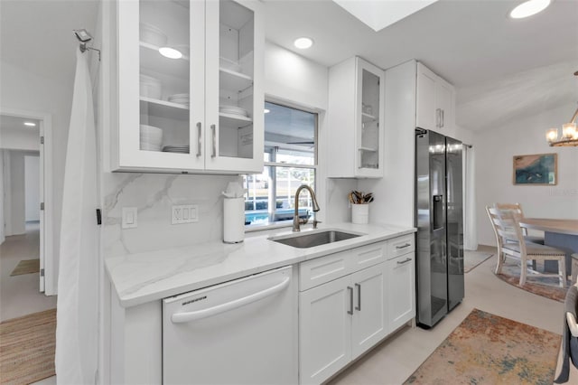 kitchen with white cabinetry, sink, light stone counters, stainless steel refrigerator with ice dispenser, and white dishwasher