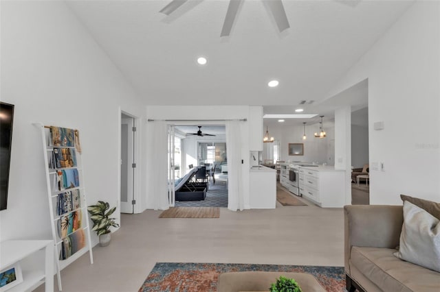 living room featuring ceiling fan with notable chandelier