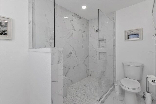 bathroom with tiled shower and toilet