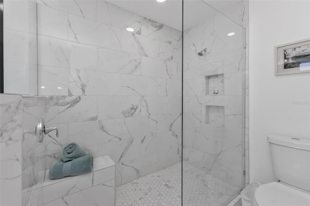 bathroom featuring a tile shower and toilet