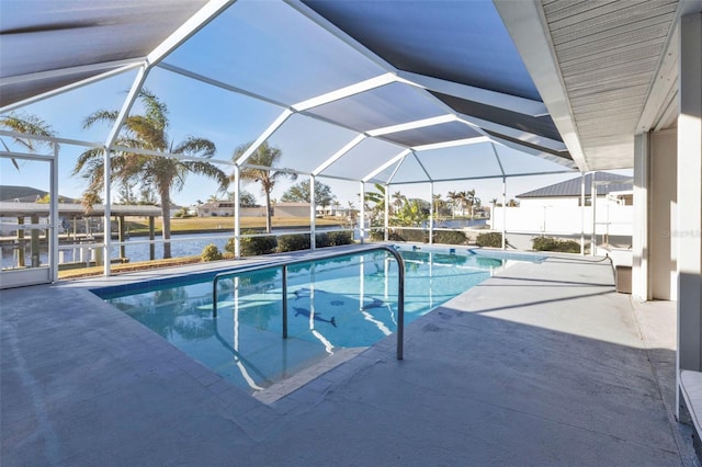 view of swimming pool with glass enclosure, a water view, and a patio