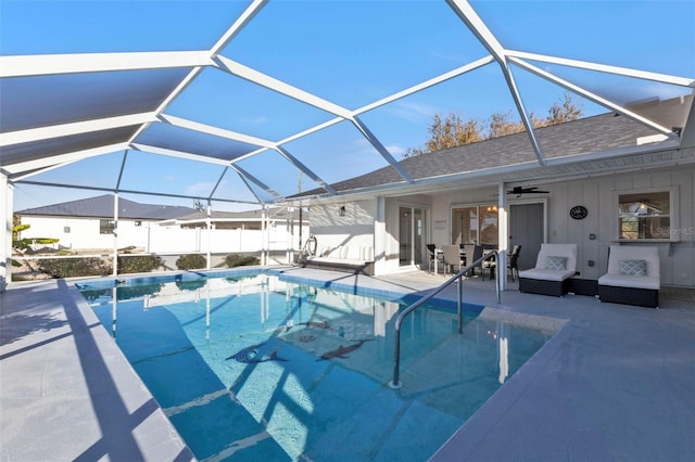 view of pool featuring a patio, glass enclosure, and ceiling fan