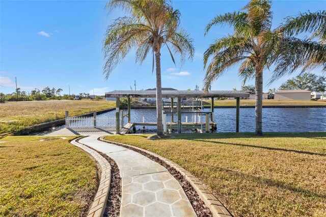 dock area with a lawn and a water view