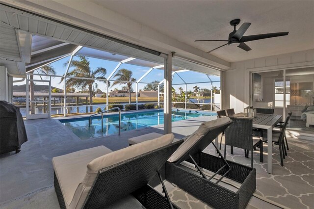 view of pool with area for grilling, a lanai, ceiling fan, a water view, and a patio