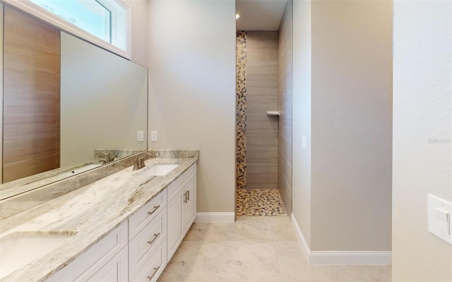 bathroom featuring a tile shower and vanity