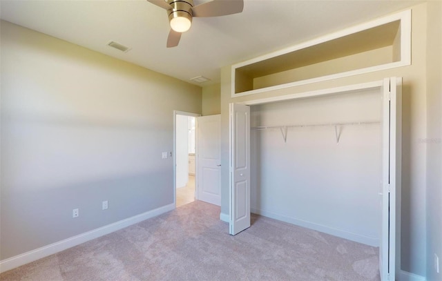 unfurnished bedroom featuring light carpet, a closet, and ceiling fan