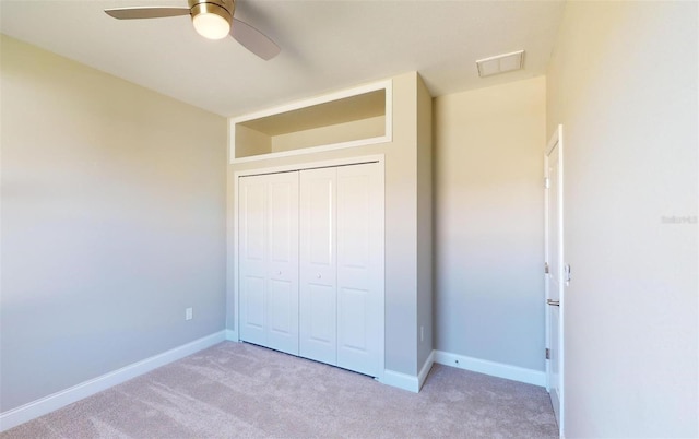 unfurnished bedroom featuring light carpet, a closet, and ceiling fan