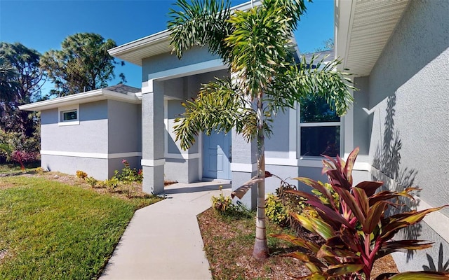 doorway to property with a lawn