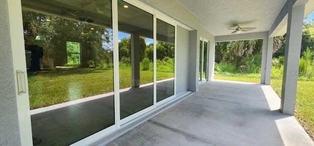 unfurnished sunroom featuring ceiling fan