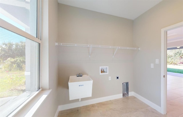 clothes washing area featuring hookup for an electric dryer, hookup for a washing machine, plenty of natural light, and sink