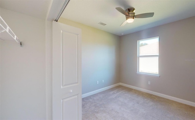 spare room with ceiling fan and light colored carpet