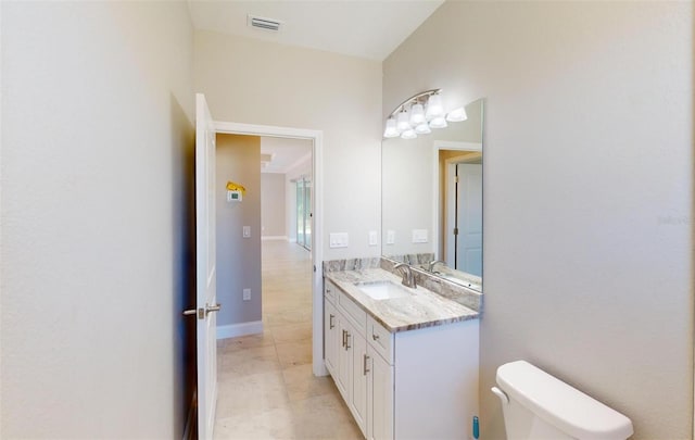 bathroom featuring tile patterned flooring, vanity, and toilet