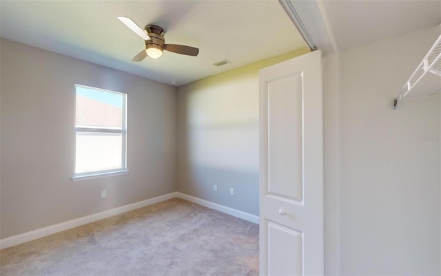 carpeted empty room featuring ceiling fan