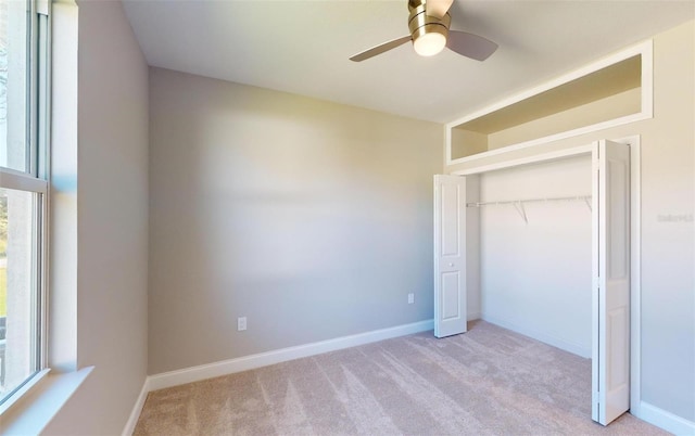 unfurnished bedroom with ceiling fan, light carpet, and a closet