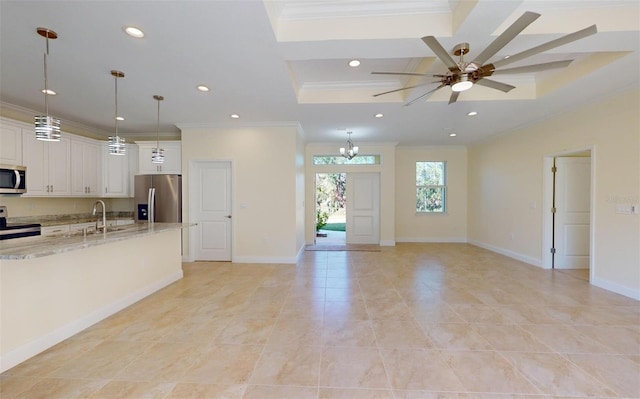 kitchen featuring white cabinets, crown molding, appliances with stainless steel finishes, decorative light fixtures, and light stone counters