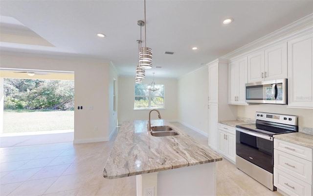 kitchen with appliances with stainless steel finishes, sink, a center island with sink, decorative light fixtures, and white cabinets