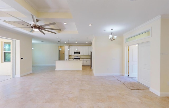 unfurnished living room featuring ceiling fan with notable chandelier, sink, crown molding, and a tray ceiling