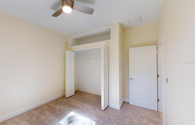 unfurnished bedroom with ceiling fan, light carpet, and a closet