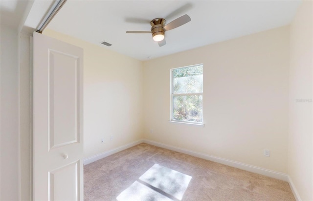 spare room featuring light carpet and ceiling fan