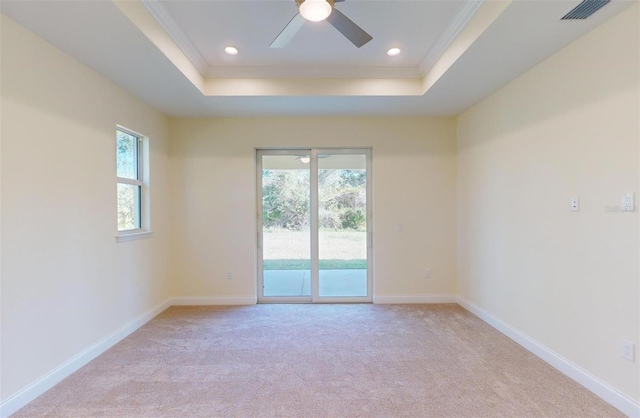 carpeted empty room featuring a raised ceiling, ceiling fan, and ornamental molding