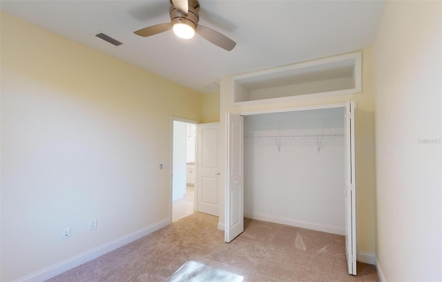 unfurnished bedroom with light carpet, a closet, and ceiling fan