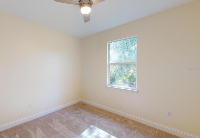 spare room featuring light carpet and ceiling fan