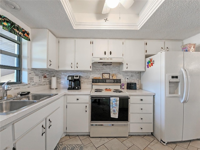 kitchen with white cabinetry, white appliances, sink, and a tray ceiling