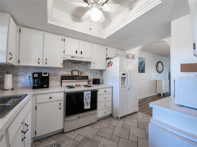 kitchen featuring white appliances, a raised ceiling, ceiling fan, a textured ceiling, and white cabinetry