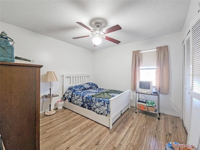 bedroom featuring a textured ceiling, light hardwood / wood-style flooring, and ceiling fan