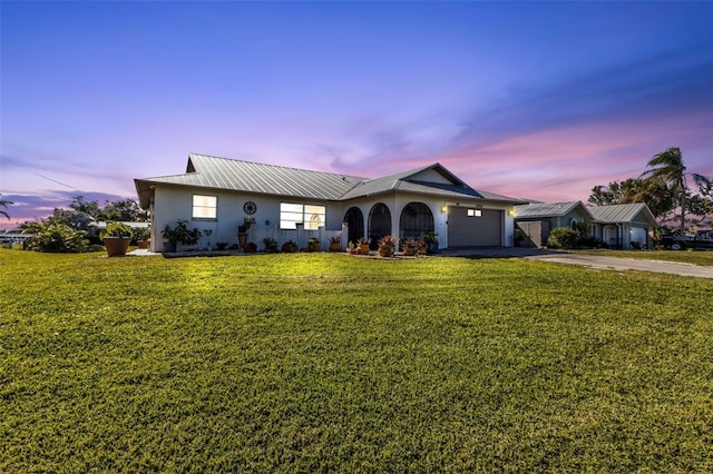 ranch-style house with a garage and a yard