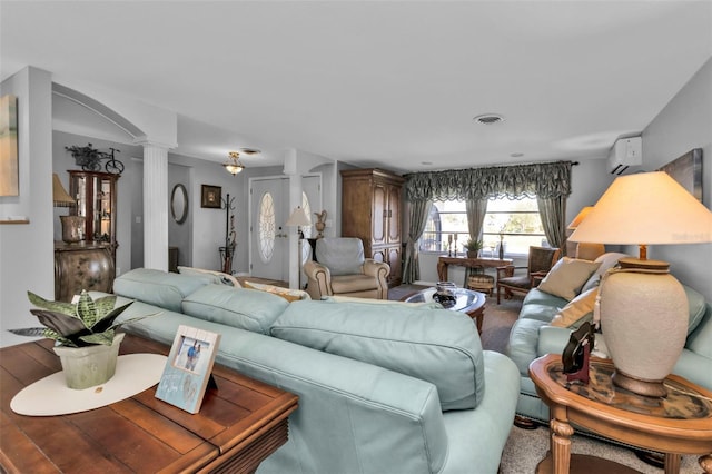 living room with decorative columns and a wall mounted AC