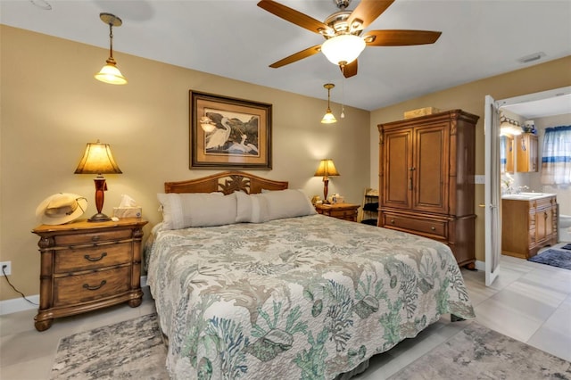 tiled bedroom featuring ceiling fan and ensuite bath