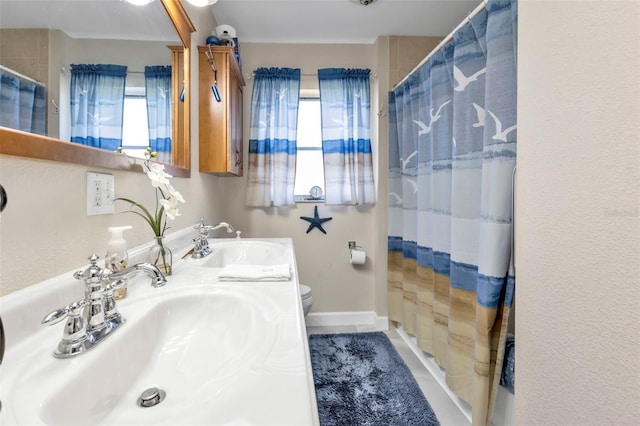 bathroom featuring vanity, toilet, curtained shower, and a healthy amount of sunlight