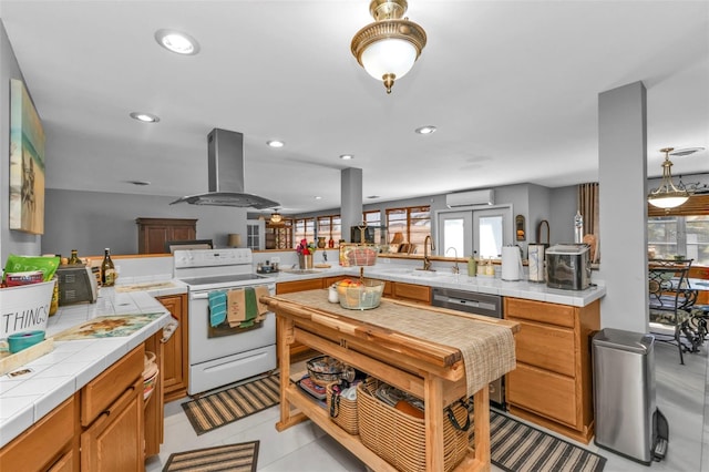 kitchen with tile countertops, kitchen peninsula, white electric range, and island exhaust hood