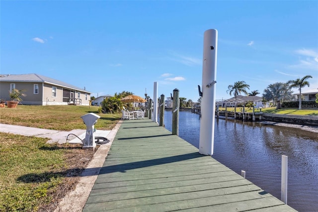 dock area with a yard and a water view