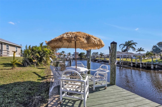 view of dock featuring a water view and a yard