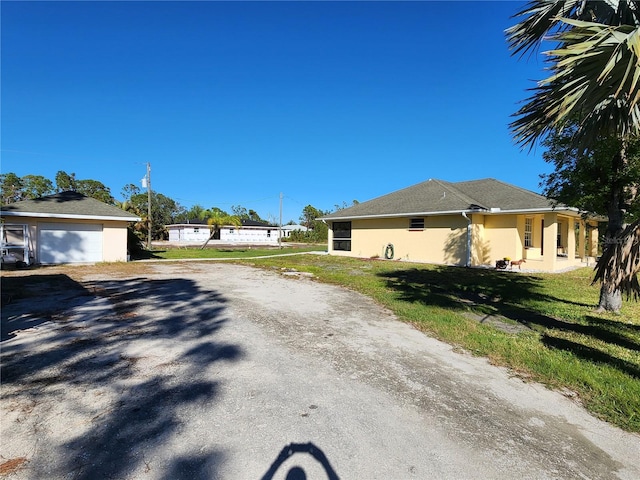 view of side of property featuring an outbuilding, a garage, and a lawn