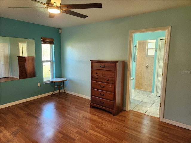 unfurnished bedroom with ensuite bathroom, hardwood / wood-style floors, and ceiling fan