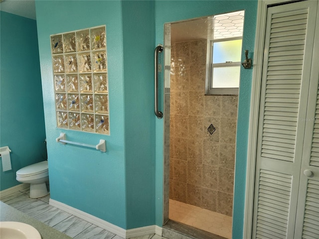 bathroom featuring tiled shower and toilet