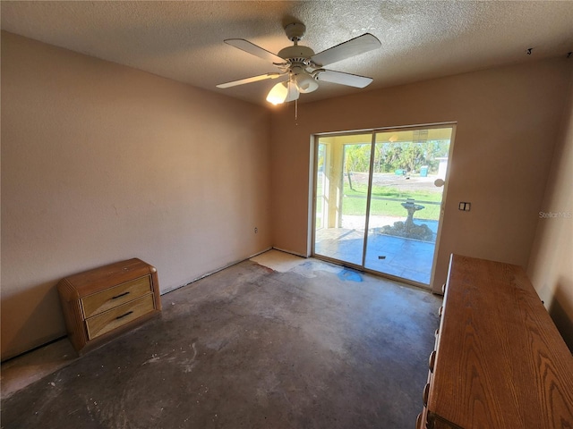 unfurnished room featuring a textured ceiling, ceiling fan, and concrete floors