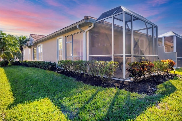 property exterior at dusk with a yard